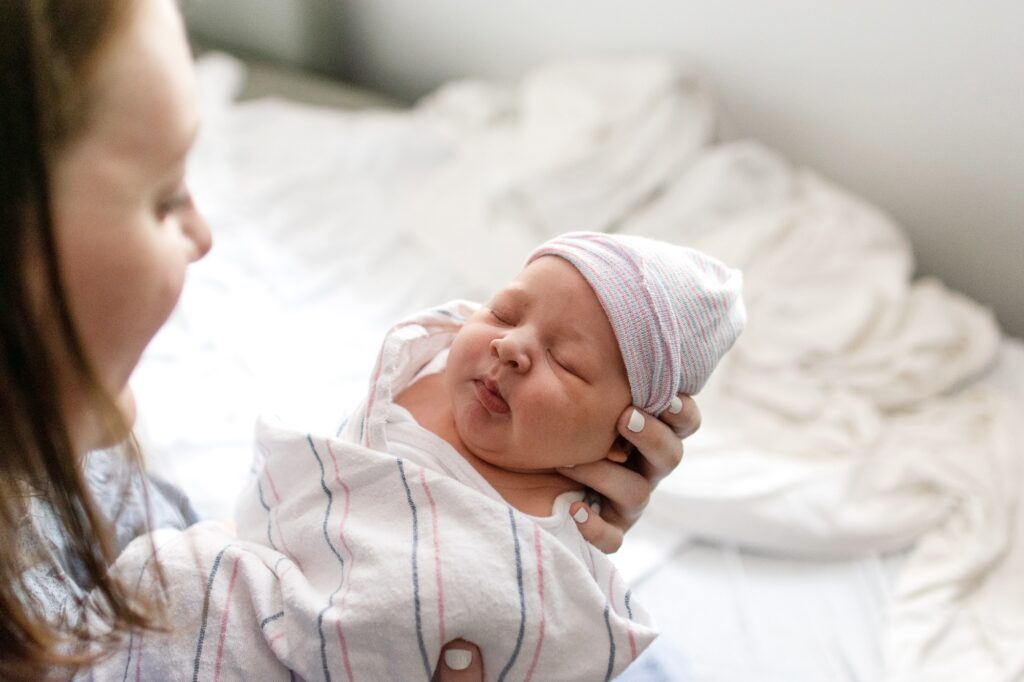 newborn baby wrapped in hospital swaddle in mom's arms