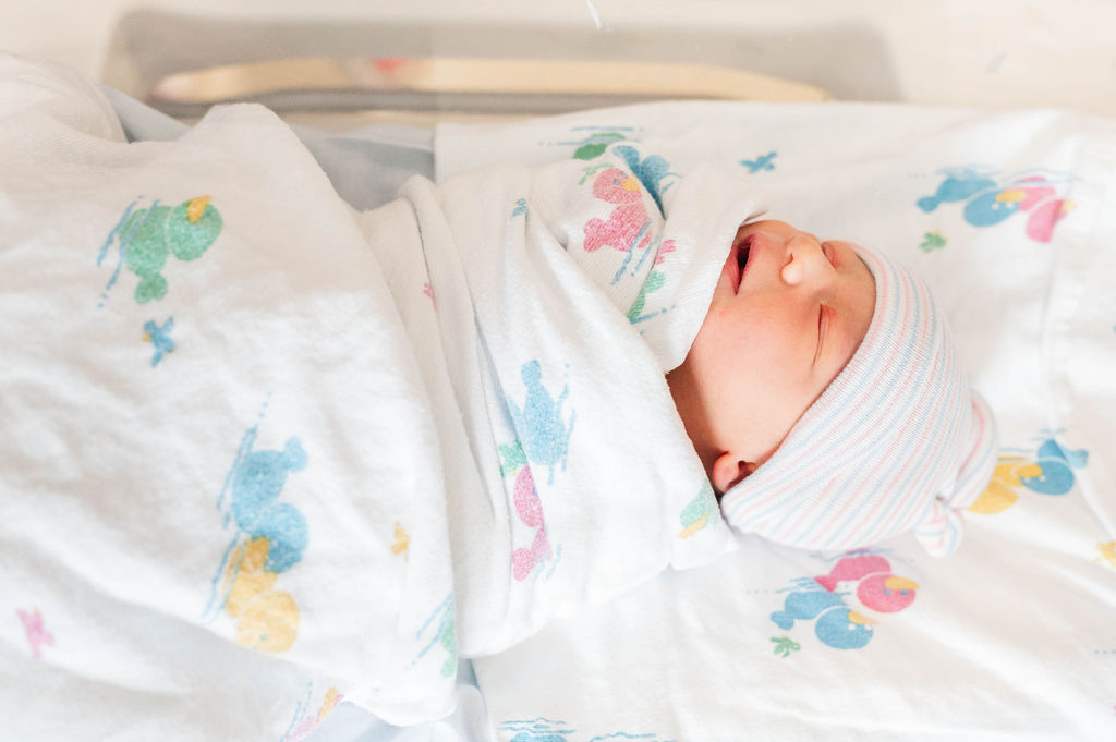 newborn baby boy wrapped in swaddle at the Hospital