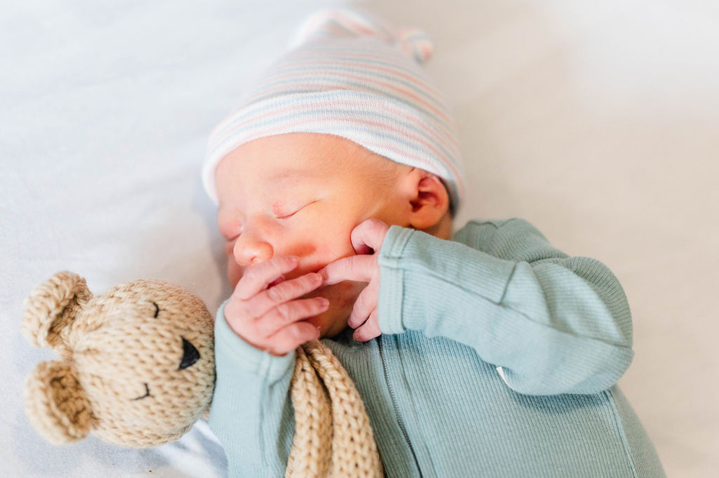 Newborn baby holding teddy bear
