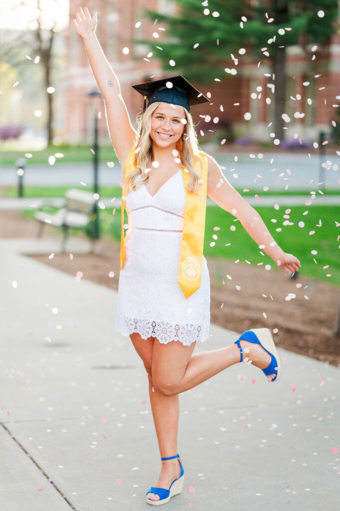 Worcester State college grad with cap on and confetti