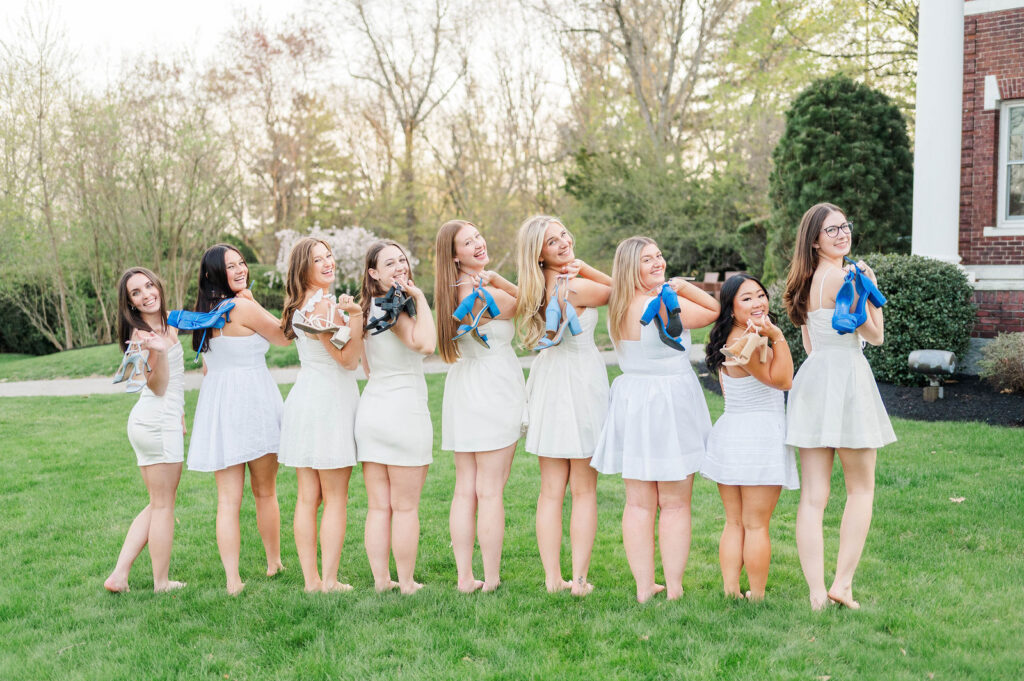 Group of college grads holding their blue shoes