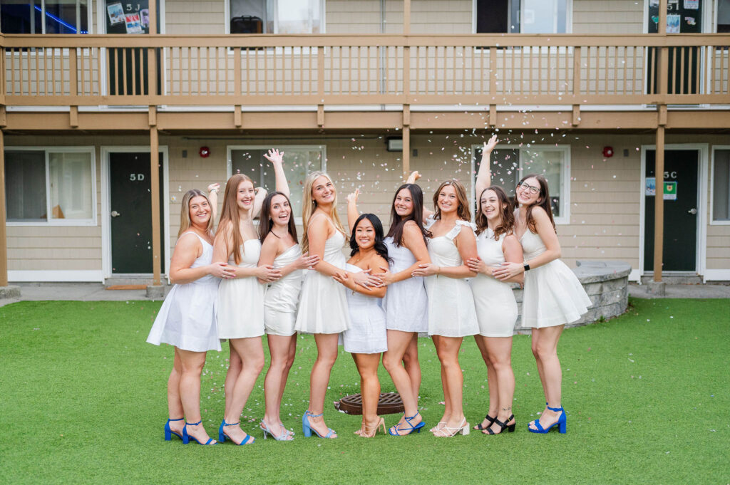 Group of college grads in front of their apartment with confetti