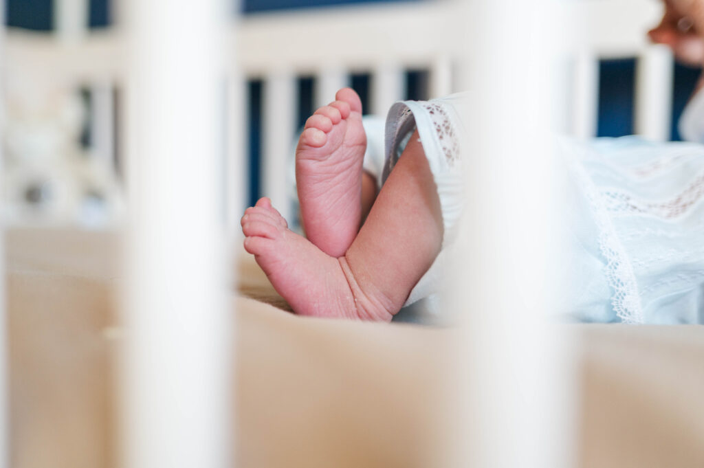 baby boy toes in a crib from the point of view of the Franklin MA Newborn photographer