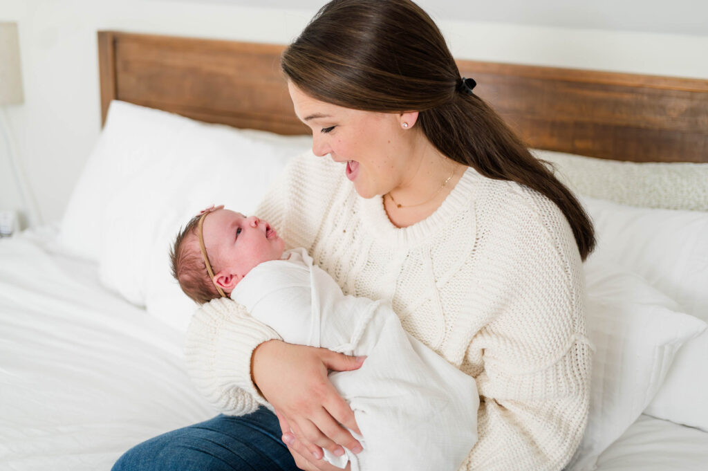 Walpole, MA newborn photographer takes image of mom and baby on bed