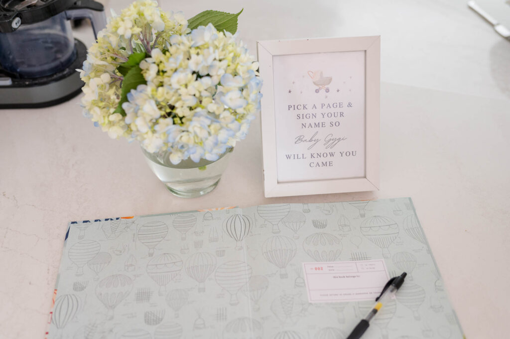 Pick a page and sign your name sign along with hydrangeas and a book with a pen