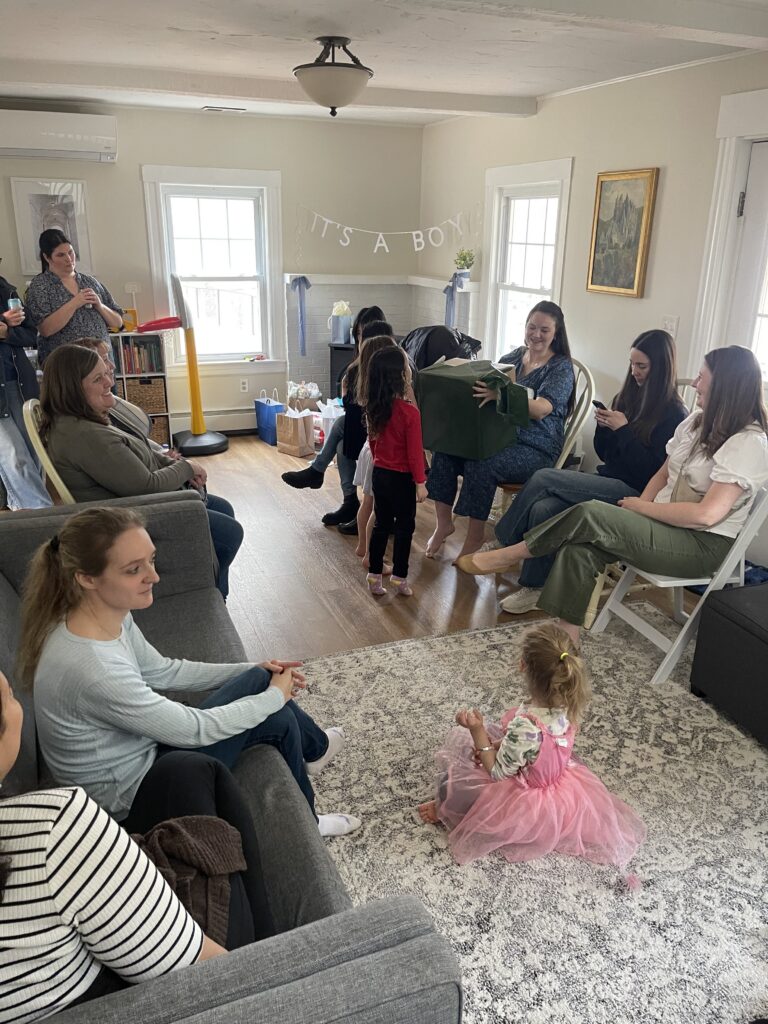 Iphone photo of pregnant mom opening her boston baby shower gifts