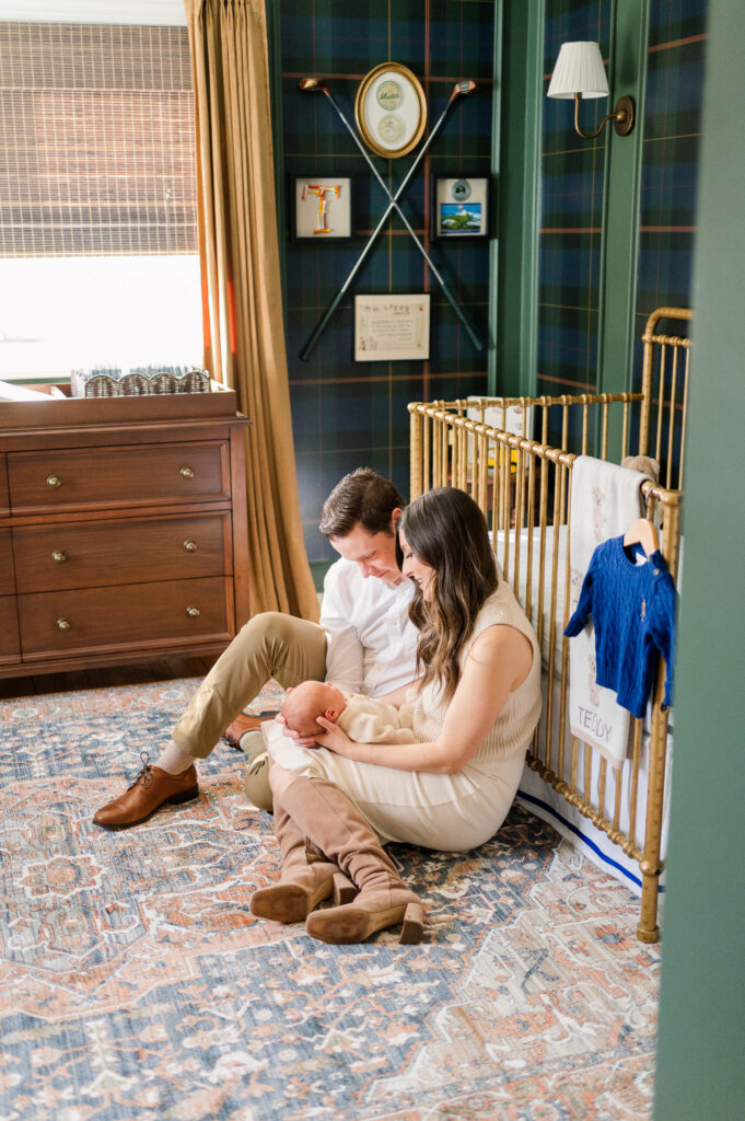 Stunning north attelboro newborn photographer photo of a nursery with mom and dad sitting by crib