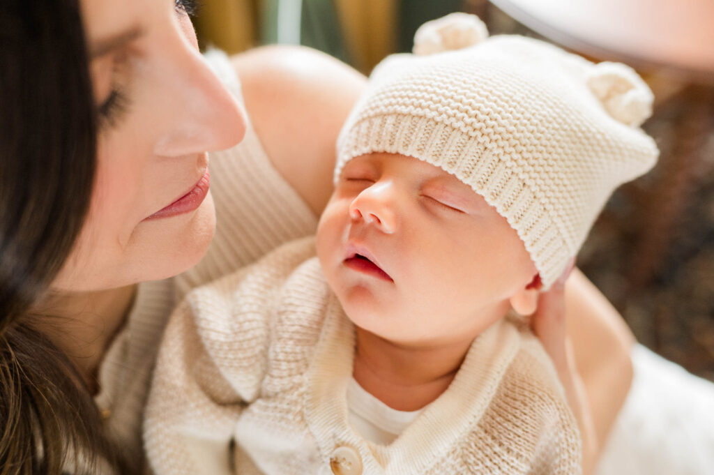 Sleeping newborn baby in mom's arms close up 