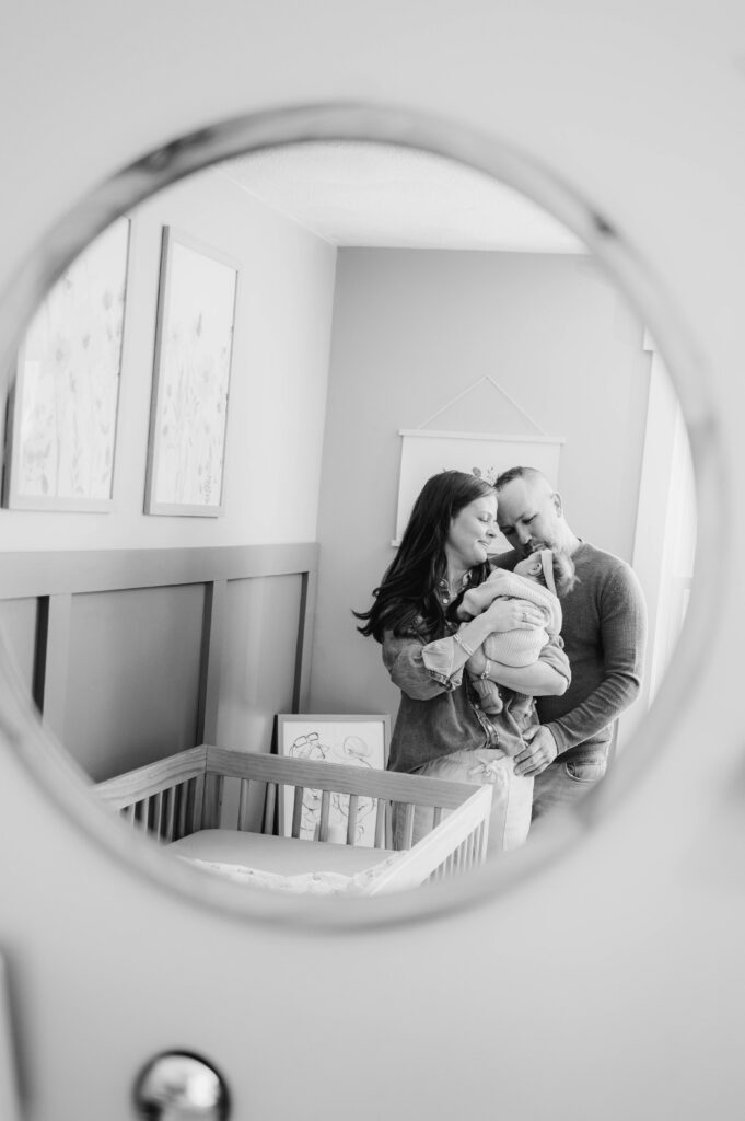 Mansfield newborn photographer image of mom and dad reflection in mirror with newborn