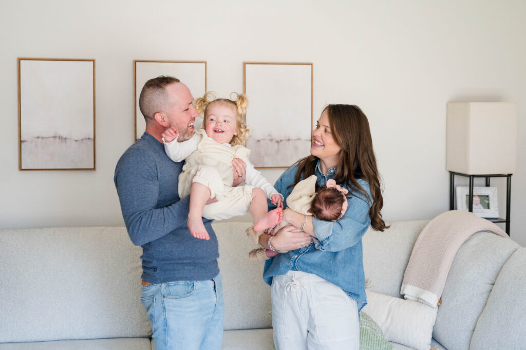 Family playing with toddler and newborn