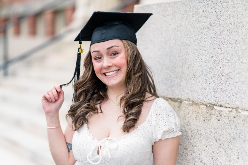 Grad wearing cap holding her tassel