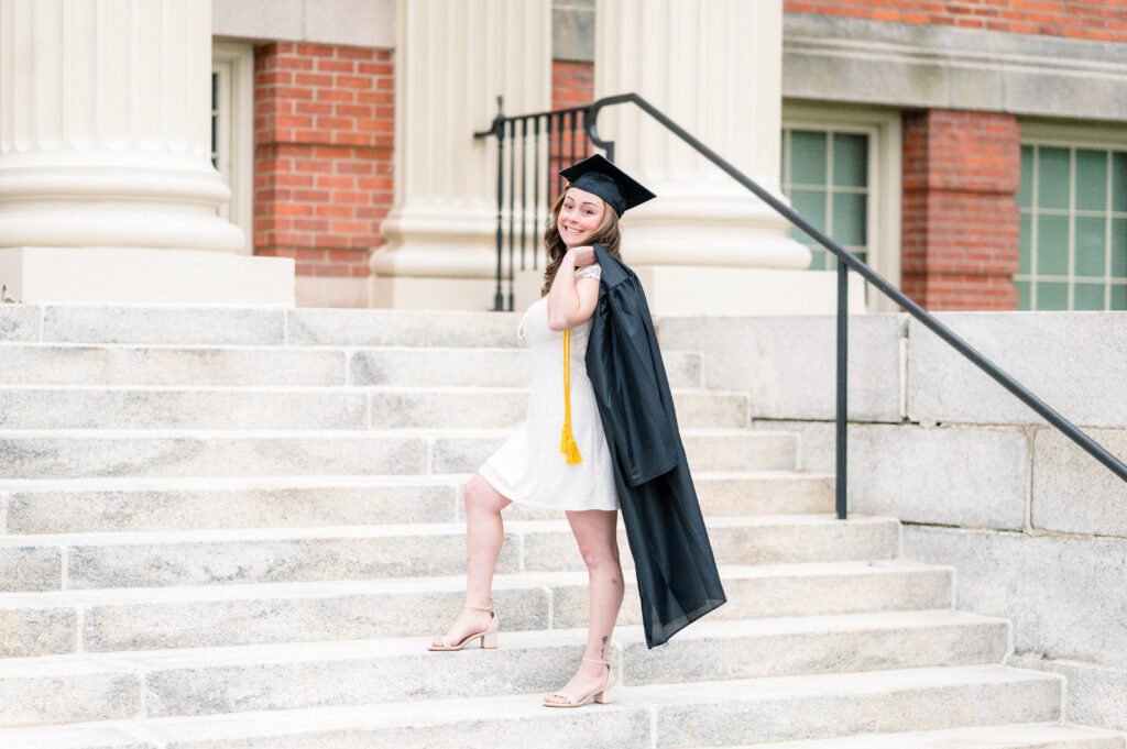 Worcester State Univeristy Grad session pose of grad holding gown