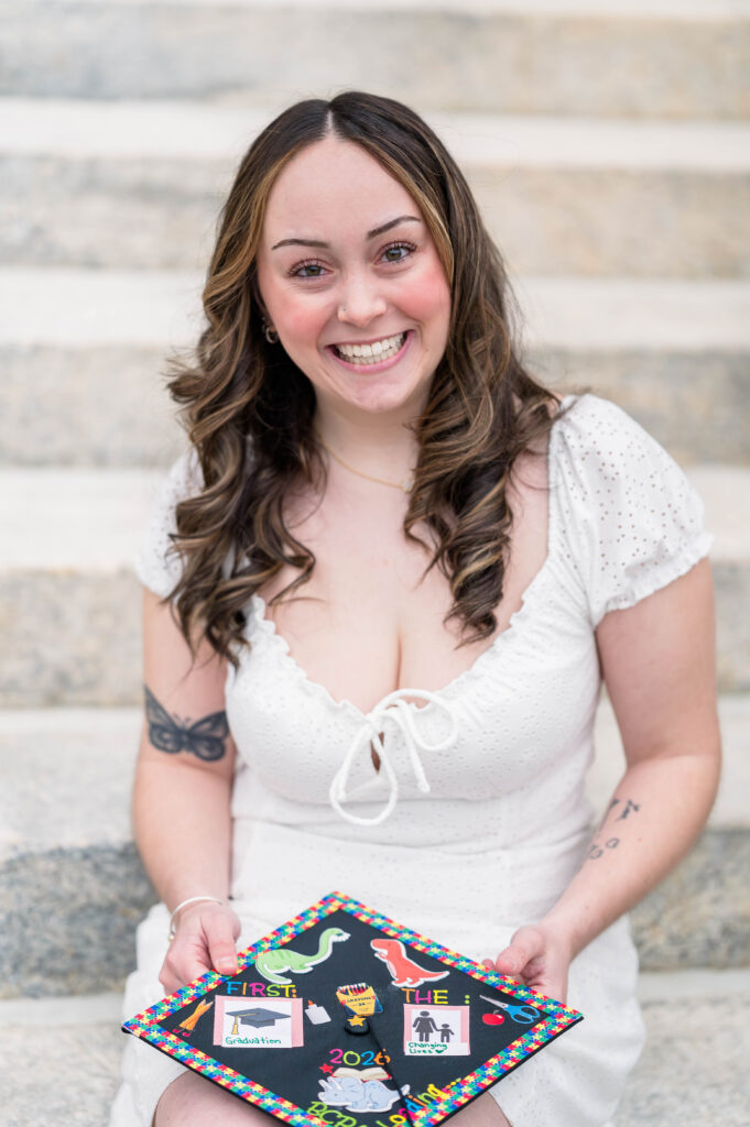 Worcester state university grad smiling and holding her cap