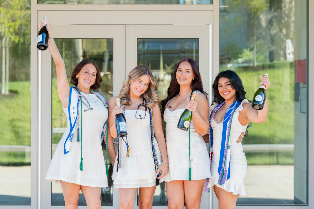 Group of graduating nurses from Assumption University holding up champagne