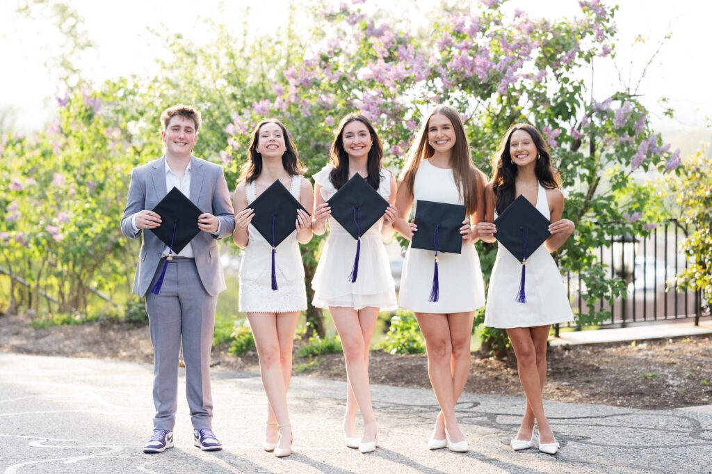 College of the Holy Cross Group Grad photo standing and smiling with caps