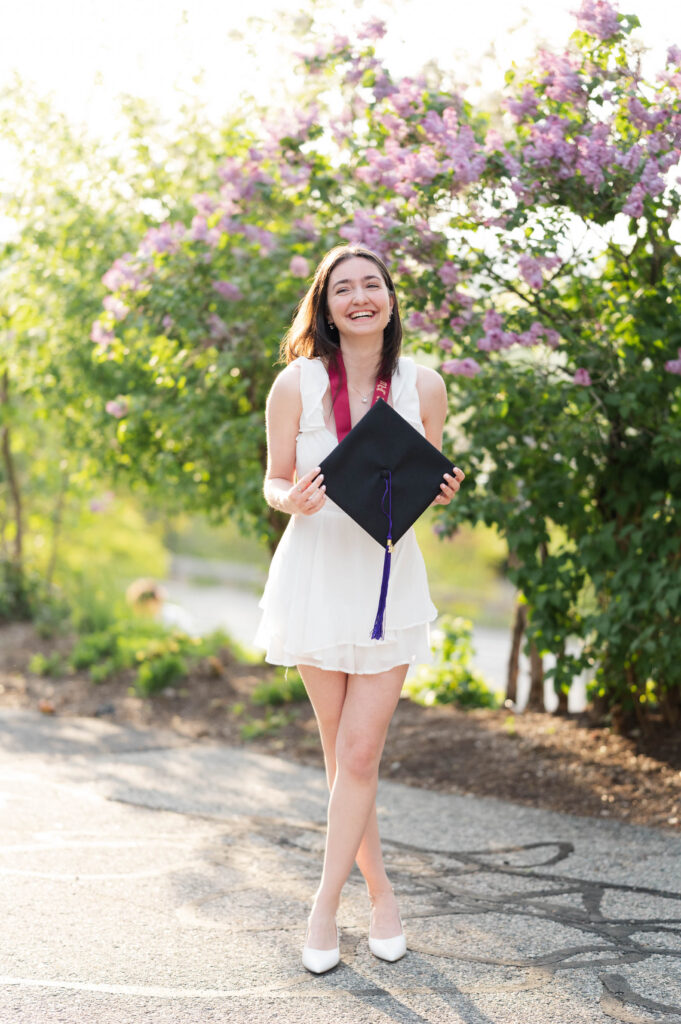 College of the Holy Cross grad posing with cap in hands