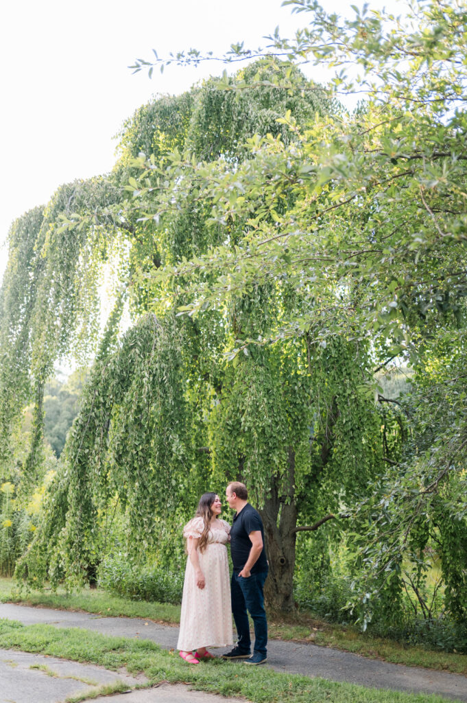 Maternity shoot image in Arnold Arboretum of mom and dad smiling at each other