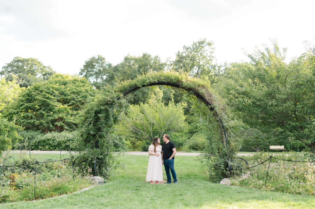 Mom and dad smiling at each other at Arnold Arboretum archway