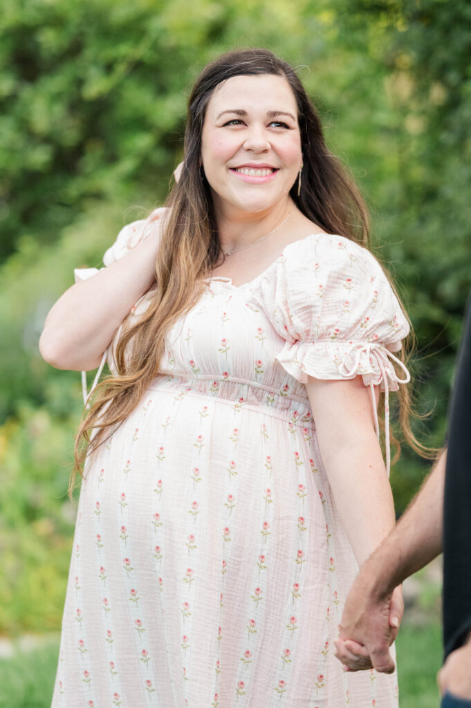 Expecting mom smiling at husband for maternity shoot at the Arnold Arboretum